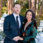 a man and woman hold hands and smile in the snow