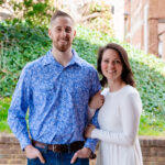 a man and a woman interlock arms and smile outside a building in winchester va